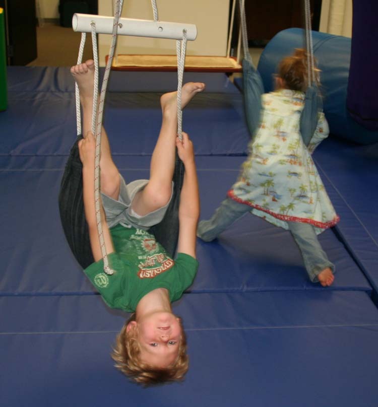 Two children are playing on a blue mat.