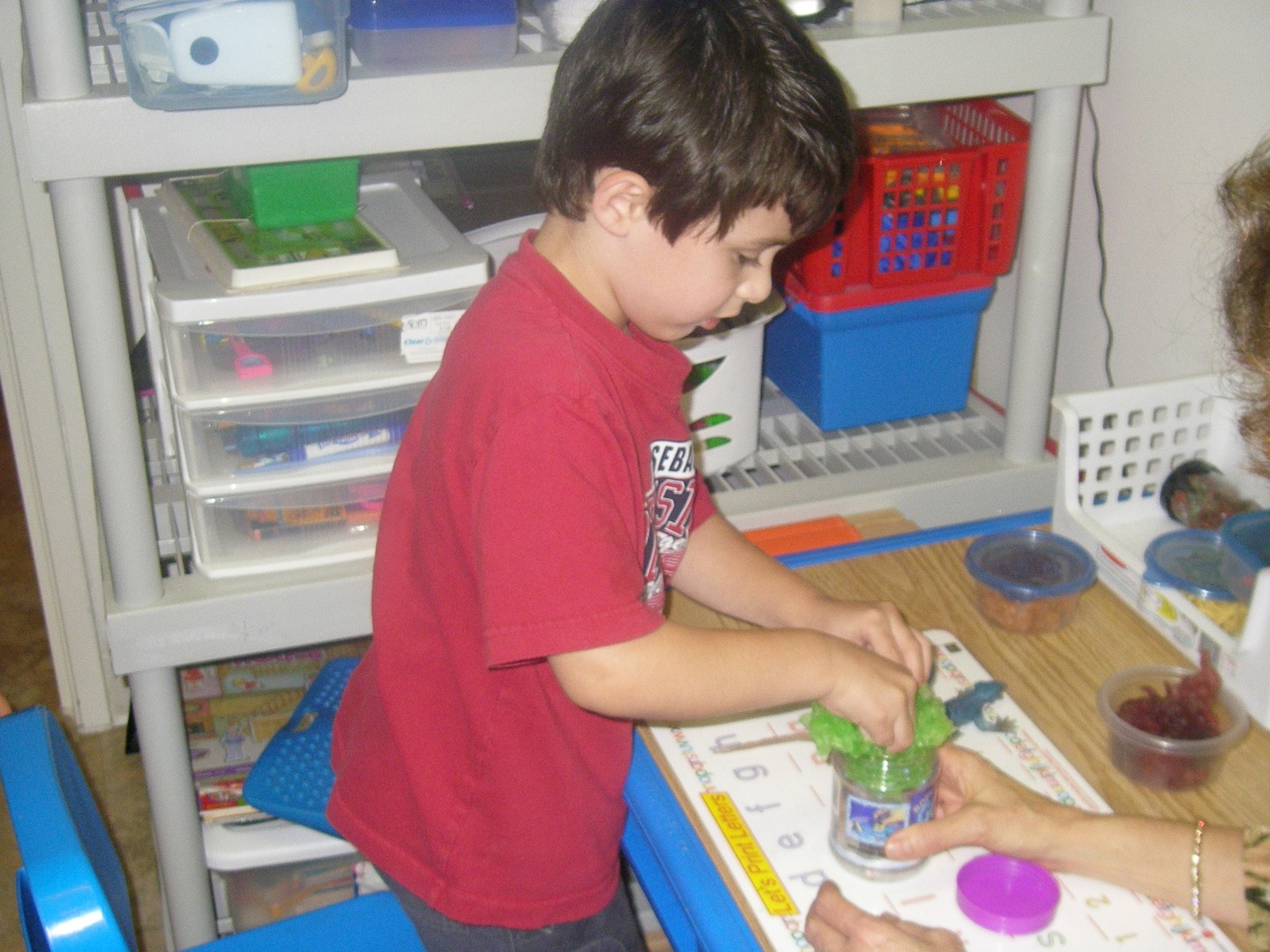 A young boy is painting with his hands.