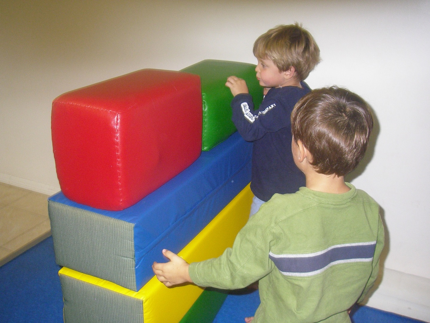 Two young boys playing with a large toy.
