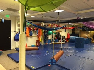 A room with several different colored mats and ropes.